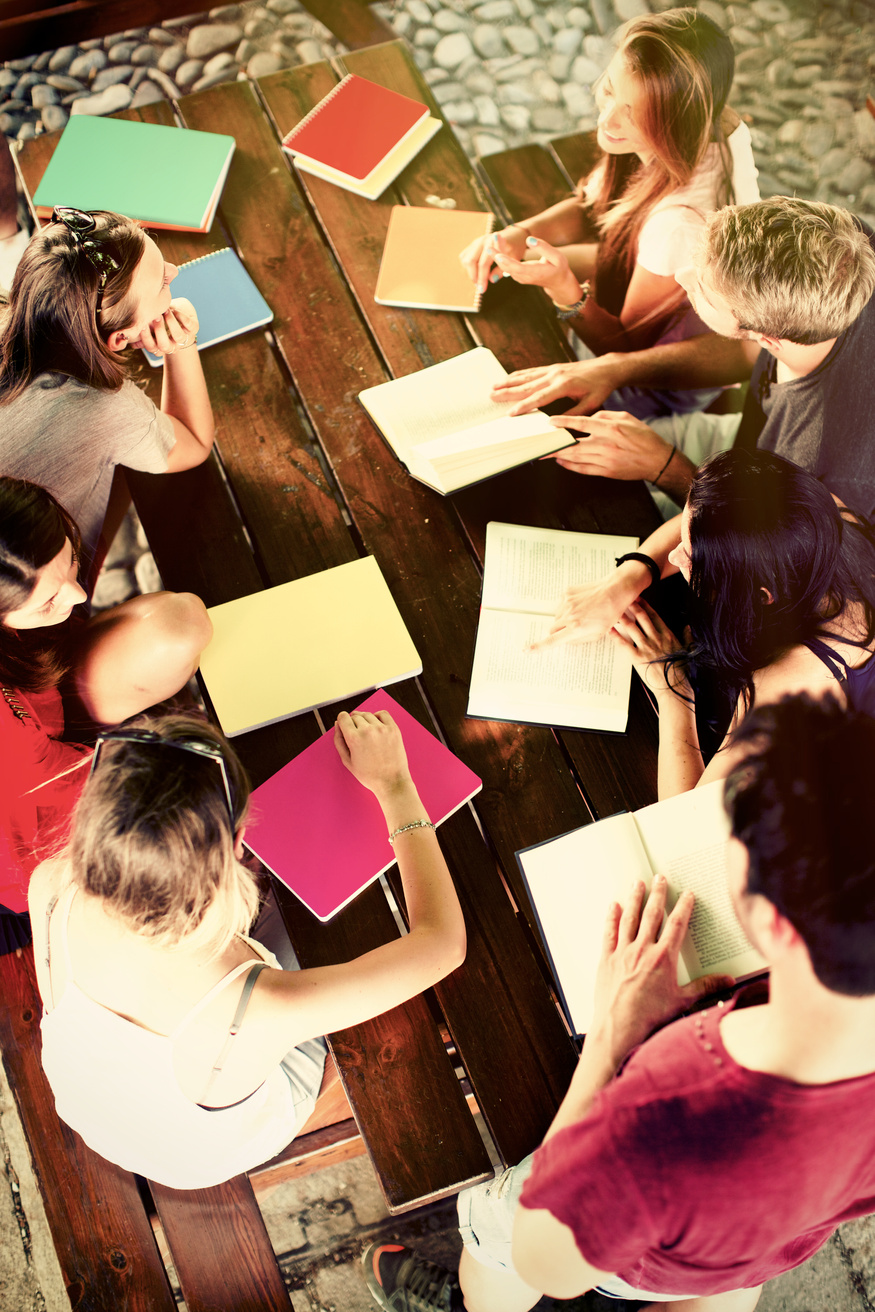 Small group of people working together with notebooks.